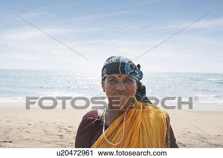 Stock Image - Portrait of mature Indian woman smiling at Vagator Beach. Fotosearch