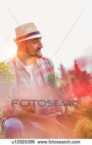 Portrait of mature male gardener holding plant on pot View Large Photo Image Stock Photograph - Portrait of mature male gardener holding plant on pot. Fotosearch