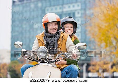 Portrait of mature man driving motorbike with his wife in park View Large Photo Image Stock Photo - Portrait of mature man driving motorbike with his wife in park. Fotosearch