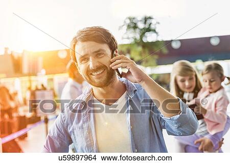 Portrait of mature man smiling while talking on smartphone in airport View Large Photo Image Picture - Portrait of mature man smiling while talking on smartphone in airport. Fotosearch