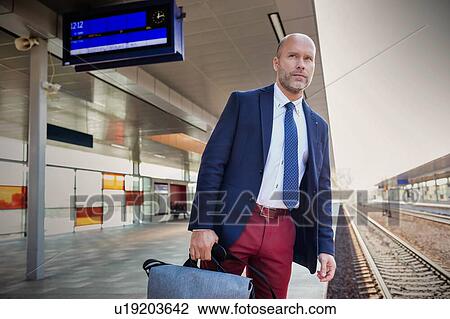 Portrait of mature man standing while waiting for the train in station View Large Photo Image Stock Image - Portrait of mature man standing while waiting for the train in station. Fotosearch