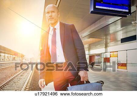 Portrait of mature man standing while waiting for the train in station View Large Photo Image Stock Photograph - Portrait of mature man standing while waiting for the train in station. Fotosearch