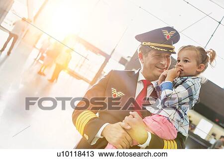 Portrait of mature pilot carrying cute little child in airport View Large Photo Image Stock Image - Portrait of mature pilot carrying cute little child in airport. Fotosearch