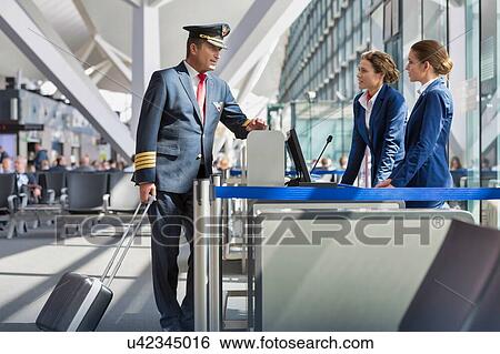 Portrait of mature pilot talking with the airport staffs in boarding gate View Large Photo Image Stock Photograph - Portrait of mature pilot talking with the airport staffs in boarding gate. Fotosearch