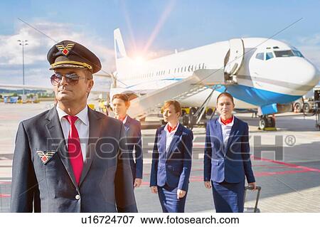 Portrait of mature pilot walking with three young beautiful flight attendants against airplane in airport View Large Photo Image Stock Photo - Portrait of mature pilot walking with three young beautiful flight attendants against airplane in airport. Fotosearch