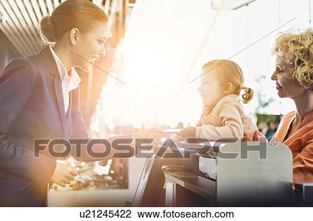 Portrait of mature woman carrying her cute little child while she is giving her passport with lens flare in airport View Large Photo Image Stock Image - Portrait of mature woman carrying her cute little child while she is giving her passport with lens flare in airport. Fotosearch