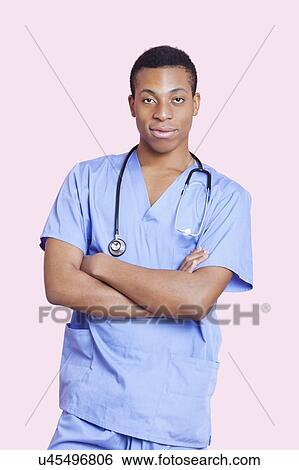 Portrait of mixed race male surgeon with arms crossed over pink background View Large Photo Image Stock Photograph - Portrait of mixed race male surgeon with arms crossed over pink background. Fotosearch