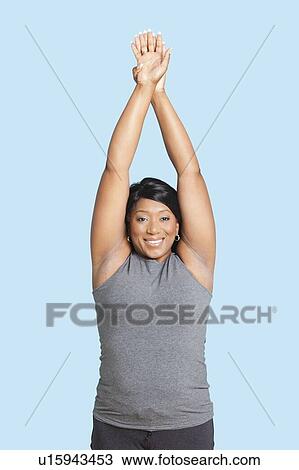 Portrait of mixed race woman stretching hands over blue background View Large Photo Image Stock Image - Portrait of mixed race woman stretching hands over blue background. Fotosearch