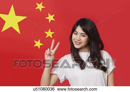 Portrait of mixed race young woman gesturing peace sign against Chinese flag View Large Photo Image Stock Photograph - Portrait of mixed race young woman gesturing peace sign against Chinese flag. Fotosearch