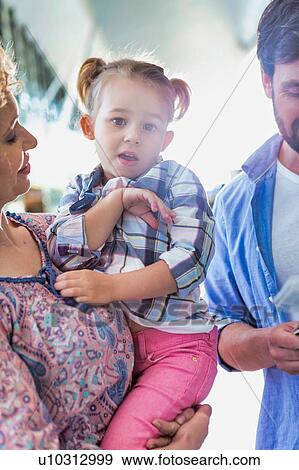 Stock Photo - Portrait of mother carrying her cute little daughter in airport. Fotosearch