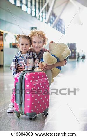 Portrait of mother reuniting with her daughter in airport with lens flare View Large Photo Image Stock Image - Portrait of mother reuniting with her daughter in airport with lens flare. Fotosearch