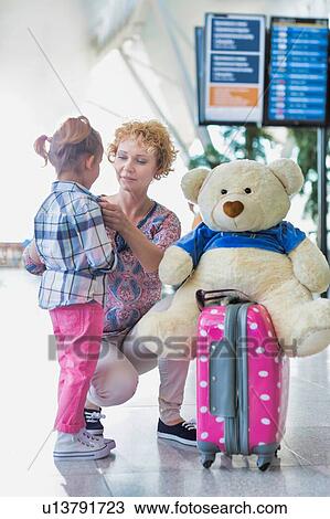 Portrait of mother reuniting with her daughter in airport with lens flare View Large Photo Image Stock Image - Portrait of mother reuniting with her daughter in airport with lens flare. Fotosearch