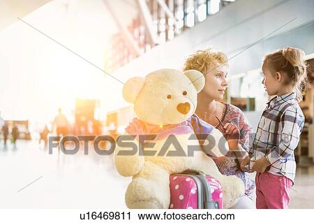 Portrait of mother reuniting with her daughter in airport with lens flare View Large Photo Image Stock Image - Portrait of mother reuniting with her daughter in airport with lens flare. Fotosearch