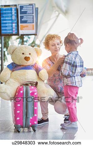 Portrait of mother reuniting with her daughter in airport with lens flare View Large Photo Image Stock Image - Portrait of mother reuniting with her daughter in airport with lens flare. Fotosearch