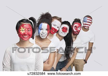 Picture - Portrait of Multi-ethnic group of friends with various national flags painted on their faces standing in queue against white background. Fotosearch
