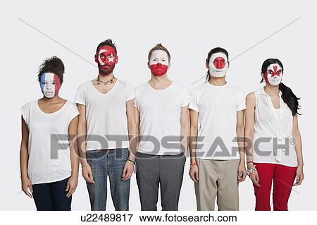 Stock Photo - Portrait of Multi-ethnic group of friends with various national flags painted on their faces standing at attention against white background. Fotosearch