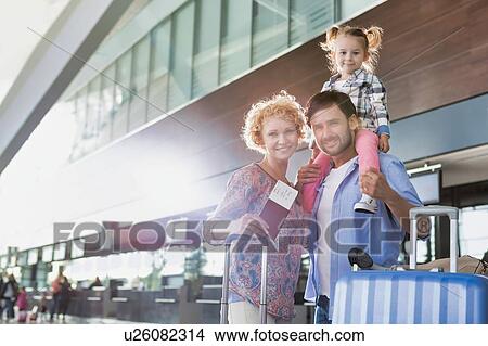 Picture - Portrait of one happy family arriving in airport with lens flare. Fotosearch