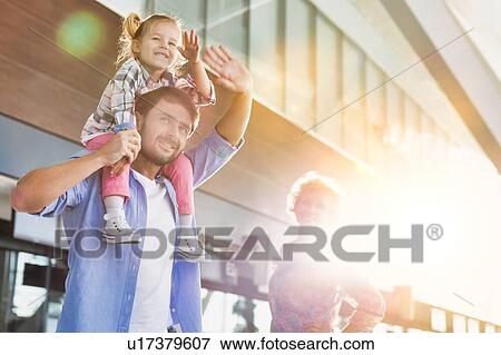 Stock Photo - Portrait of one happy family arriving in airport with lens flare. Fotosearch