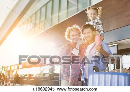 Stock Photography - Portrait of one happy family arriving in airport with lens flare. Fotosearch