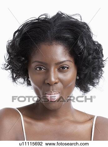 Portrait of playful young woman sticking out tongue over white background View Large Photo Image Stock Image - Portrait of playful young woman sticking out tongue over white background. Fotosearch
