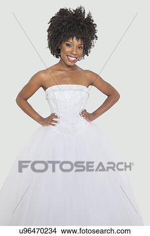 Picture - Portrait of pretty African American bride standing hands on hips against gray background. Fotosearch