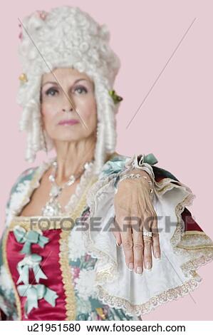 Portrait of senior queen stretching out her hand over pink background View Large Photo Image Stock Image - Portrait of senior queen stretching out her hand over pink background. Fotosearch