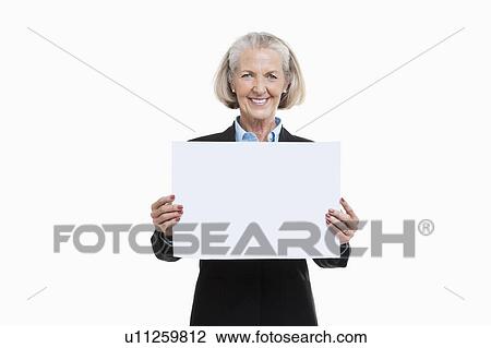 Portrait of senior woman holding blank board against white background View Large Photo Image Stock Image - Portrait of senior woman holding blank board against white background. Fotosearch