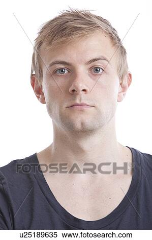 Portrait of serious young man in blue tshirt against white background View Large Photo Image Stock Photography - Portrait of serious young man in blue tshirt against white background. Fotosearch
