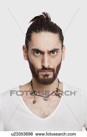 Stock Photo - Portrait of serious young man in white t-shirt over white background. Fotosearch