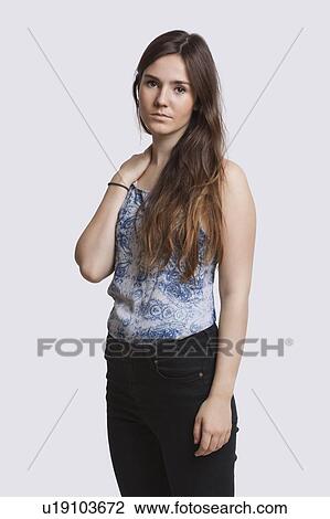 Stock Image - Portrait of serious young woman over white background. Fotosearch