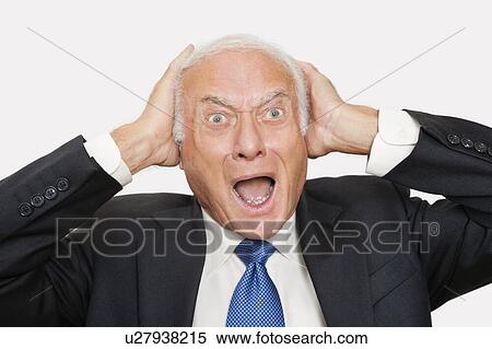 Stock Photography - Portrait of shocked elderly businessman against white background. Fotosearch