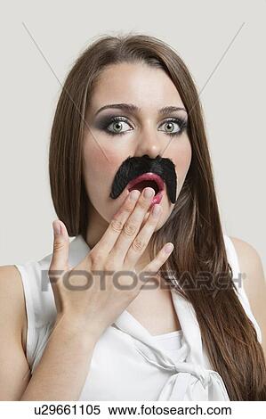 Portrait of shocked young woman with fake moustache over gray background View Large Photo Image Stock Photography - Portrait of shocked young woman with fake moustache over gray background. Fotosearch