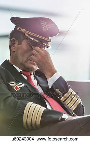 Portrait of sleepy and overworked pilot sitting in airport View Large Photo Image Picture - Portrait of sleepy and overworked pilot sitting in airport . Fotosearch