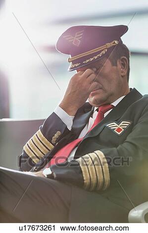Portrait of sleepy and overworked pilot sitting in airport View Large Photo Image Stock Image - Portrait of sleepy and overworked pilot sitting in airport . Fotosearch