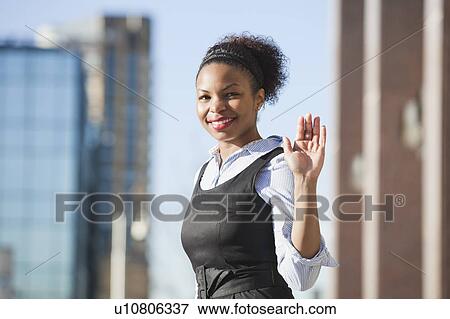 Portrait of smiling African American young woman in formals waving hand View Large Photo Image Stock Photo - Portrait of smiling African American young woman in formals waving hand. Fotosearch