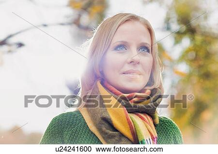 Stock Image - Portrait of Smiling beautiful mature woman in park. Fotosearch