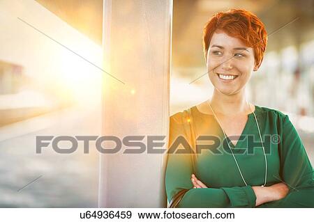Stock Photo - Portrait of smiling confident businesswoman standing with arms crossed. Fotosearch