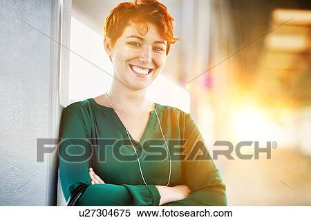 Stock Photography - Portrait of smiling confident businesswoman standing with arms crossed. Fotosearch