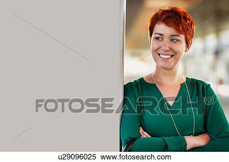 Stock Photography - Portrait of smiling confident businesswoman standing with arms crossed. Fotosearch