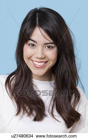 Portrait of smiling mixed race young woman over blue background View Large Photo Image Picture - Portrait of smiling mixed race young woman over blue background. Fotosearch