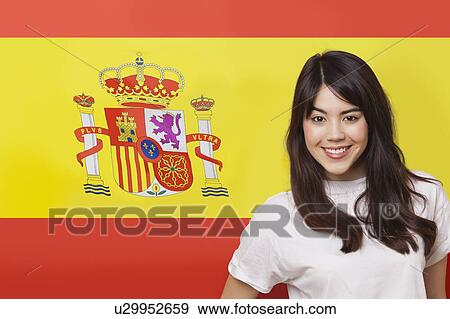 Portrait of smiling mixed race young woman against Spanish flag View Large Photo Image Stock Photo - Portrait of smiling mixed race young woman against Spanish flag. Fotosearch