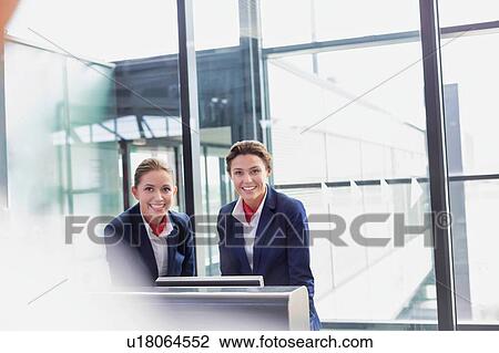 Portrait of smiling young attractive passenger service agent standing in airport View Large Photo Image Stock Image - Portrait of smiling young attractive passenger service agent standing in airport. Fotosearch
