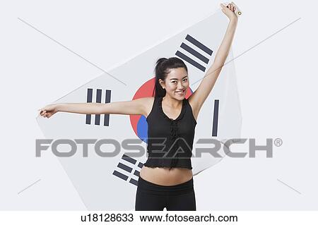 Portrait of smiling young woman holding Korean flag over white background View Large Photo Image Stock Image - Portrait of smiling young woman holding Korean flag over white background. Fotosearch