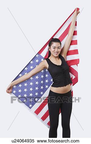 Portrait of smiling young woman holding American flag over white background View Large Photo Image Stock Photography - Portrait of smiling young woman holding American flag over white background. Fotosearch