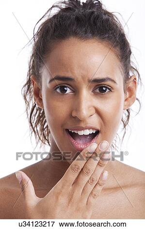 Stock Photo - Portrait of surprised young woman hand on chin against white background. Fotosearch
