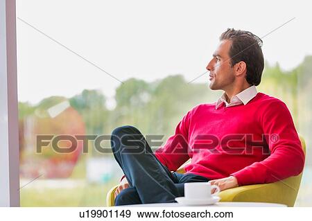 Portrait of thougtful businessman sitting while drinking coffee in lobby View Large Photo Image Stock Photo - Portrait of thougtful businessman sitting while drinking coffee in lobby. Fotosearch
