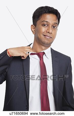 Portrait of tired young Asian businessman against white background View Large Photo Image Picture - Portrait of tired young Asian businessman against white background. Fotosearch