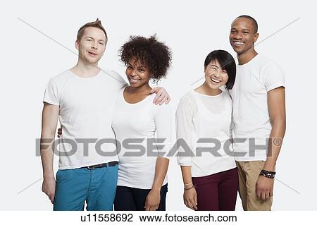 Stock Image - Portrait of two cheerful young couples in casuals standing together over white background. Fotosearch