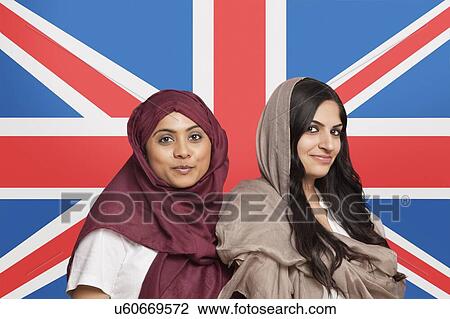 Portrait of two young Muslim women in traditional clothing standing against British flag View Large Photo Image Stock Image - Portrait of two young Muslim women in traditional clothing standing against British flag. Fotosearch