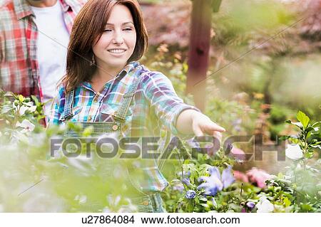Portrait of woman buyer pointing flower in shop View Large Photo Image Picture - Portrait of woman buyer pointing flower in shop. Fotosearch
